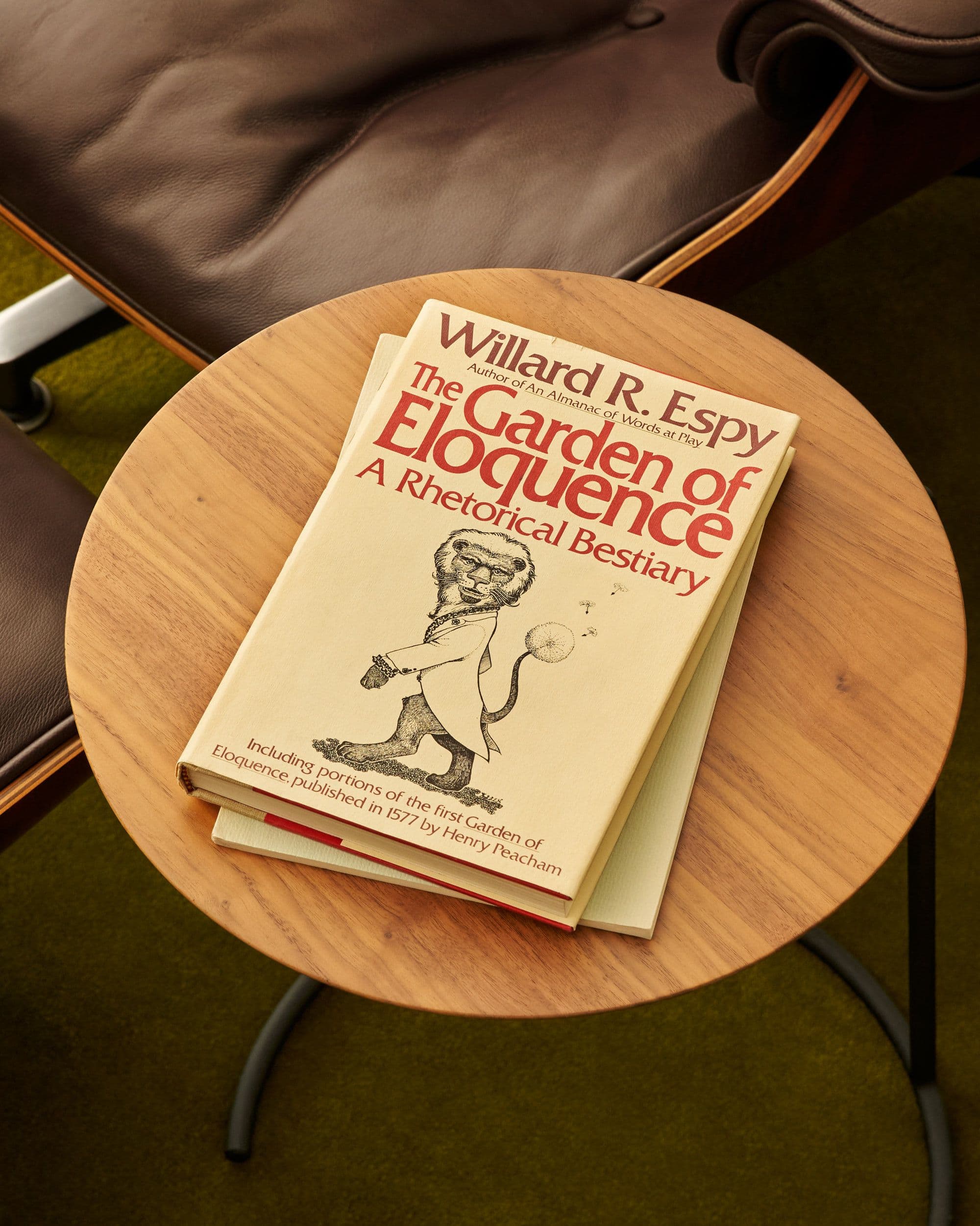 A hardcover book sitting on top of a small wooden table.